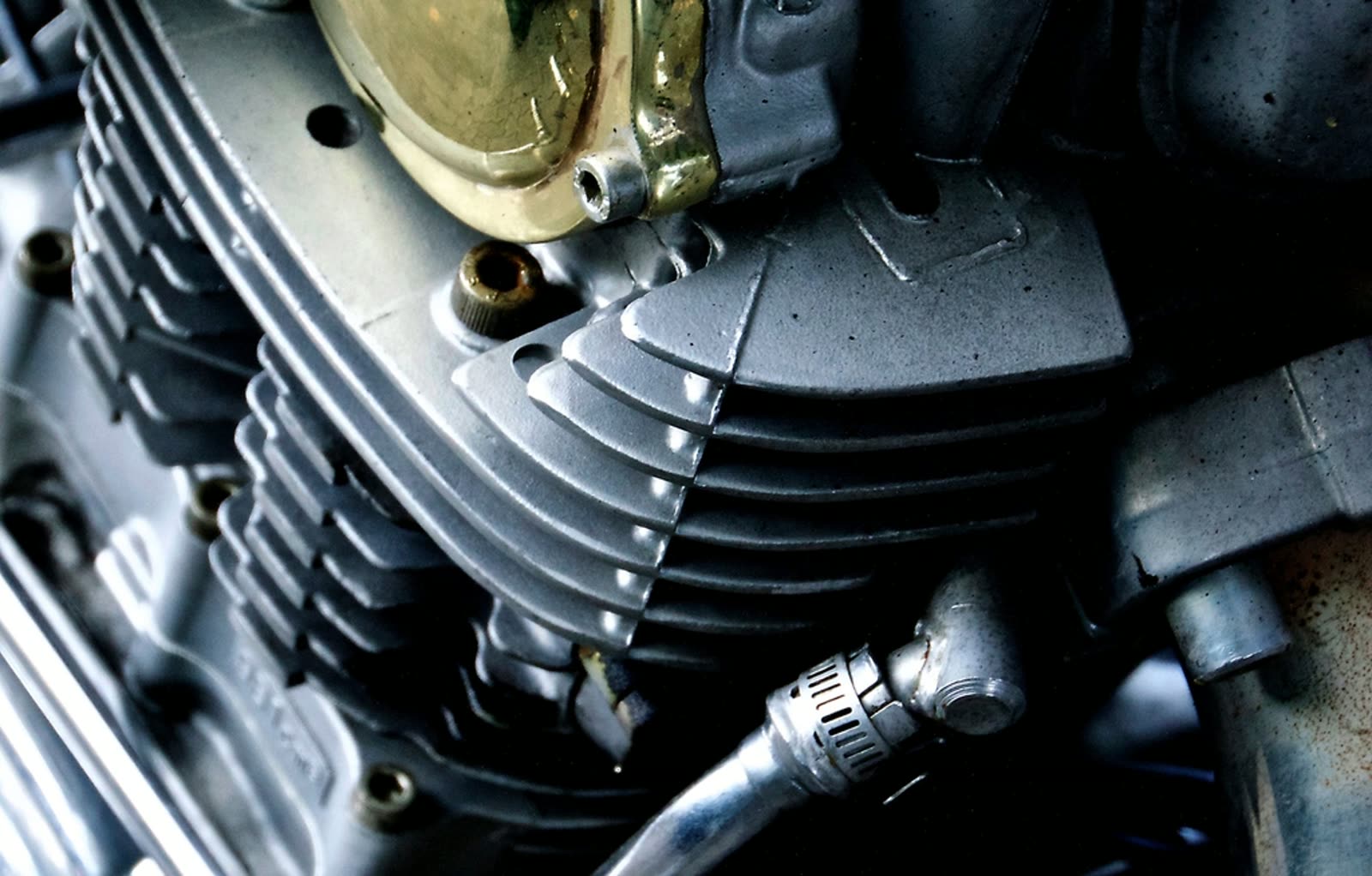 A close-up of a motorcycle engine — cooling fins, cylinder head and cabling.