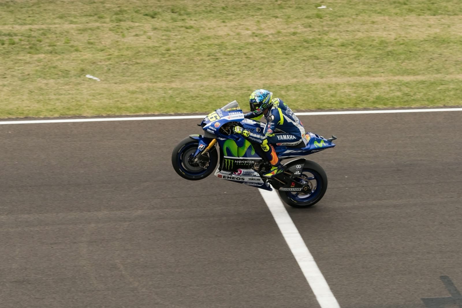 A road racer cranked over mid-corner on a Yamaha, knee out, on a circuit.